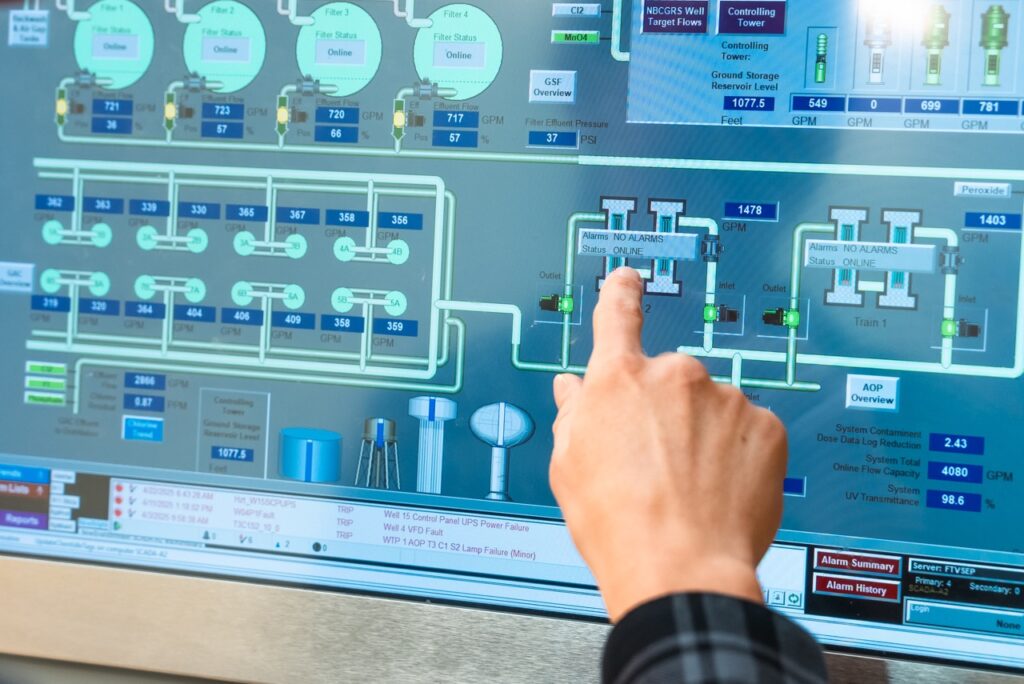 An operator using a water treatment SCADA interface with process status and alarms